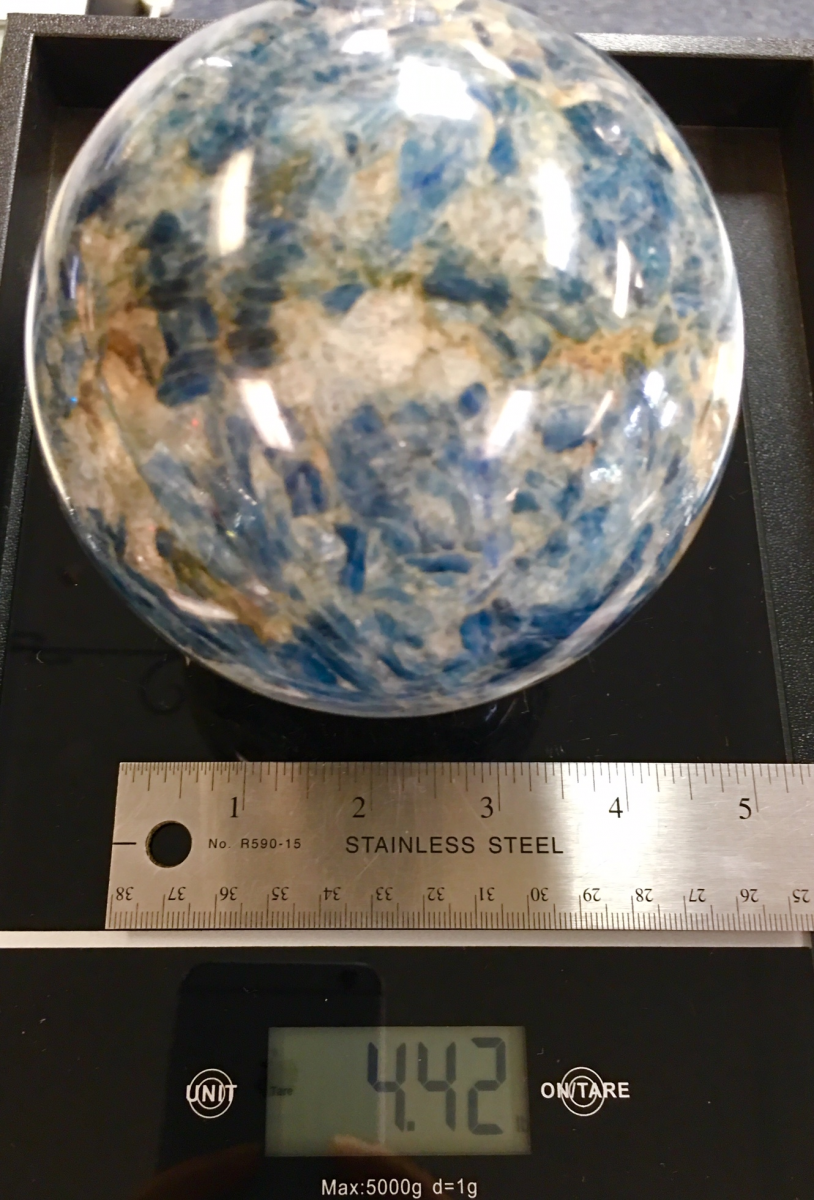 a blue kyanite sphere about 4 inches in diameter weighing almost 4 and a half pounds. shown on a digital scale with ruler for size